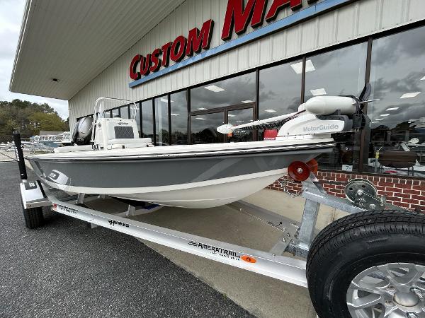 Slide: The Image of 2024 Hewes Redfisher 18 boat on trailer outside Custom Marine dealership. - 2