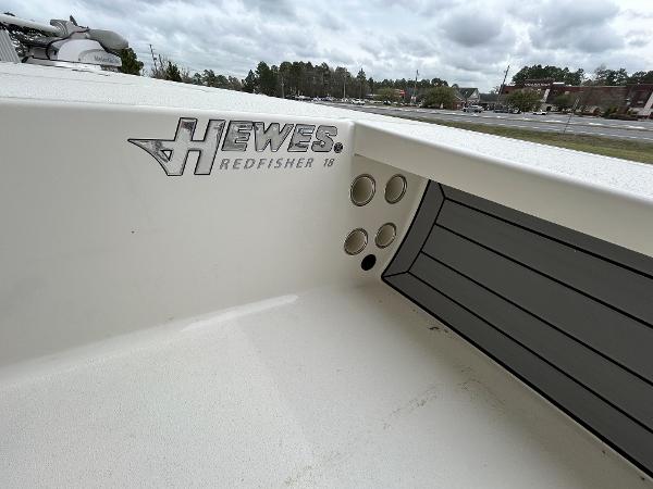 Slide: The Image of 2024 Hewes Redfisher 18 boat interior with logo and rod holders. - 23