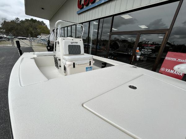 Slide: The Image of 2024 Hewes Redfisher 18 boat displayed outside a dealership. - 7