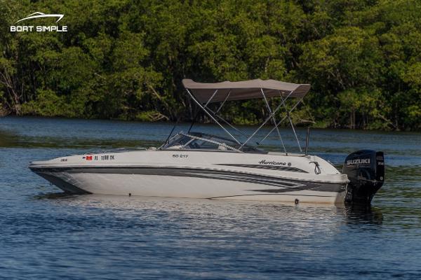 Slide: The Image of 2022 Hurricane 217 SD boat with Suzuki outboard motor on a calm lake. - 1