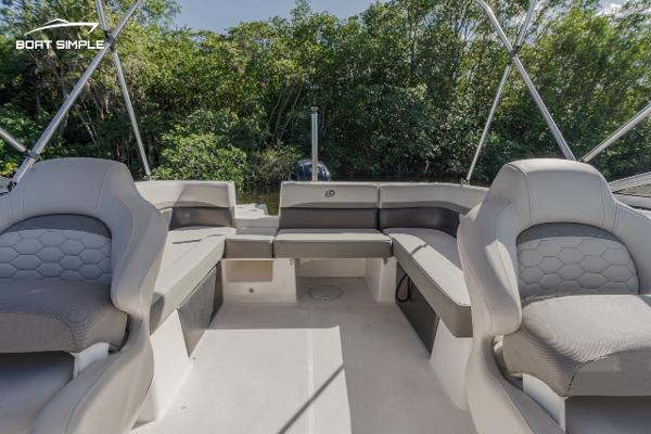 Slide: The Image of 2022 Hurricane 217 SD boat interior with spacious seating and lush greenery background. - 10