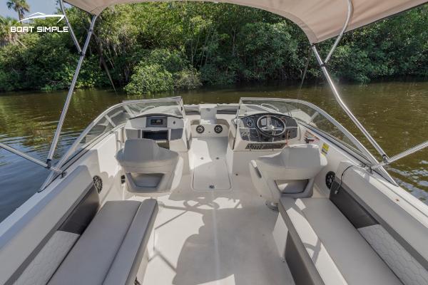 Slide: The Image of 2022 Hurricane 217 SD boat interior with seating and steering console on a calm river. - 6