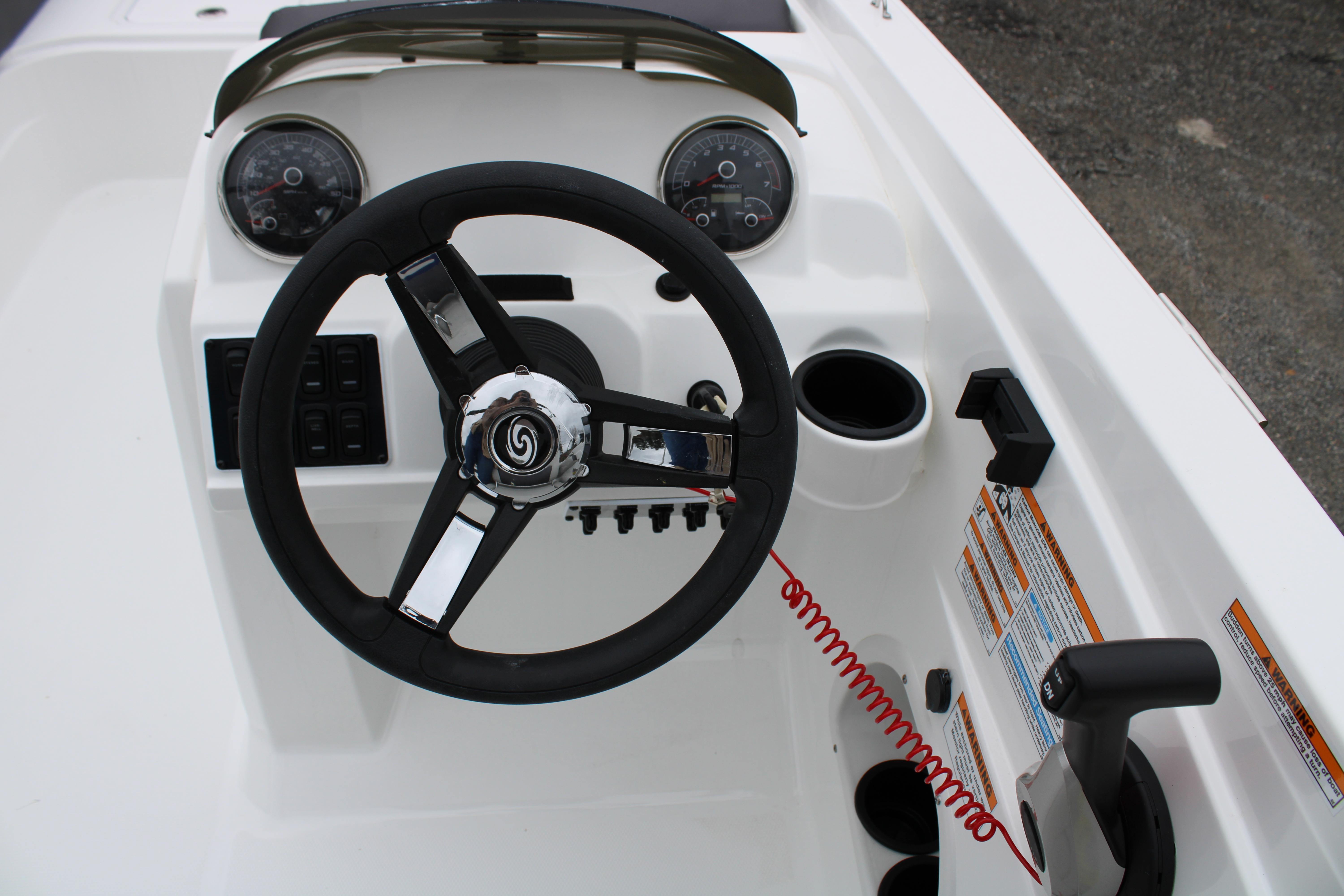 Slide: The Image of 2023 Hurricane SunDeck Sport 205 OB boat dashboard with steering wheel and controls. - 14