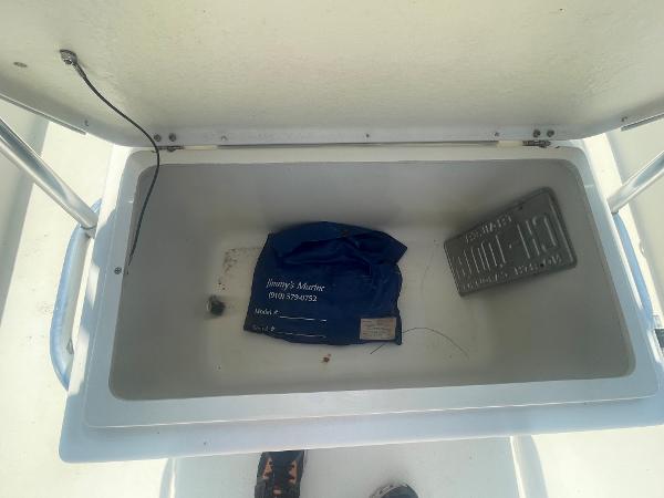 Slide: The Image of Open storage compartment of a 2006 Intruder Pro Marine 20 boat with items inside. - 12