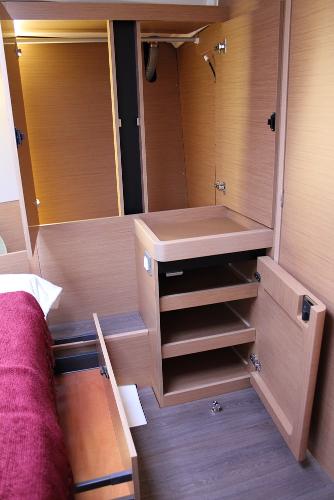 Slide: The Image of Interior of 2025 Jeanneau Sun Odyssey 440 yacht, featuring wooden cabinetry and storage space. - 13