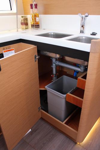 Slide: The Image of 2025 Jeanneau Sun Odyssey 440 kitchen sink area with open cabinet and storage. - 16