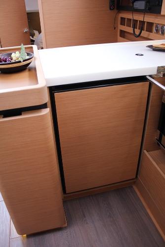 Slide: The Image of 2025 Jeanneau Sun Odyssey 440 yacht interior kitchen with modern wood cabinetry and countertop. - 17