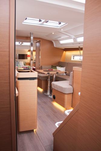 Slide: The Image of Interior of 2025 Jeanneau Sun Odyssey 440 yacht, featuring modern wood finishes and cozy seating. - 33