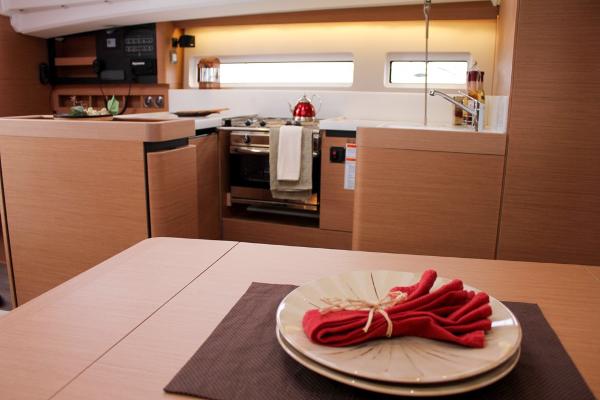 Slide: The Image of Interior of 2025 Jeanneau Sun Odyssey 440 yacht, featuring modern kitchen and dining area. - 38