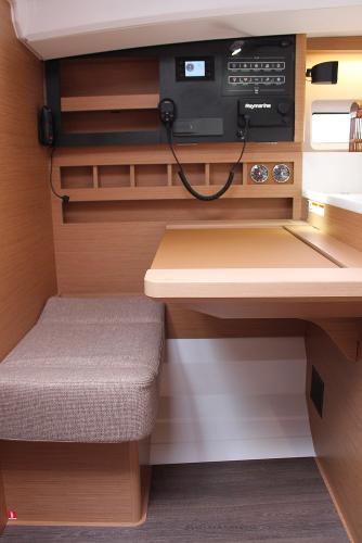 Slide: The Image of 2025 Jeanneau Sun Odyssey 440 interior, featuring navigation station with control panel and seating. - 5