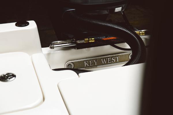 Slide: The Image of 2024 Key West 188 Bay Reef boat detail with branding and engine components. - 49