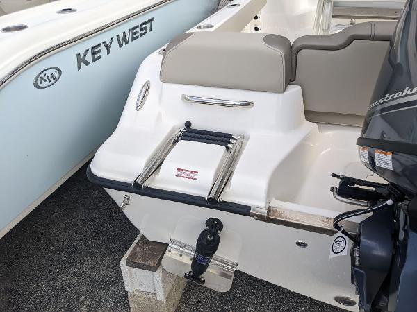 Slide: The Image of 2024 Key West 189 FS boat stern with swim ladder and outboard motor. - 3