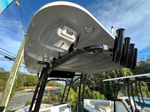 Slide: The Image of 2024 Key West 219 FS boat with T-top and rod holders, under a clear blue sky. - 16