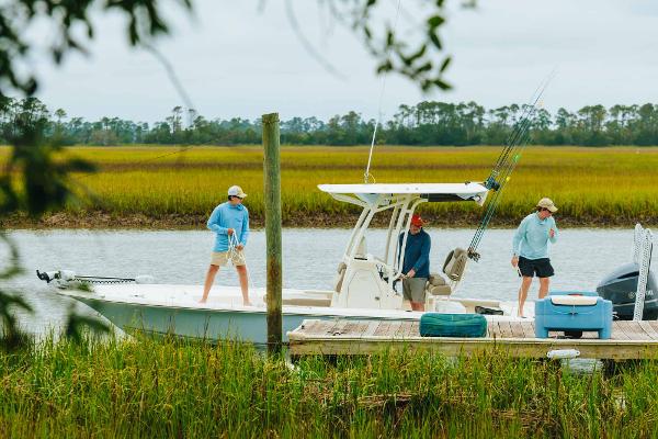 Slide: The Image of 2023 Key West 250 Bay Reef boat with people fishing near a dock. - 34