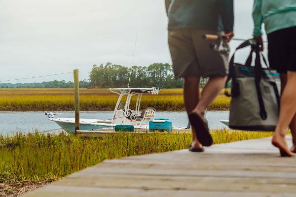 Slide: The Image of Couple walking towards 2023 Key West 250 Bay Reef boat docked by marshland. - 40