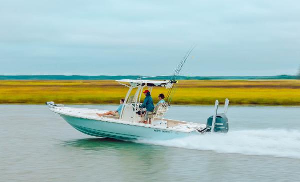 Slide: The Image of 2023 Key West 250 Bay Reef boat speeding on water with passengers. - 47