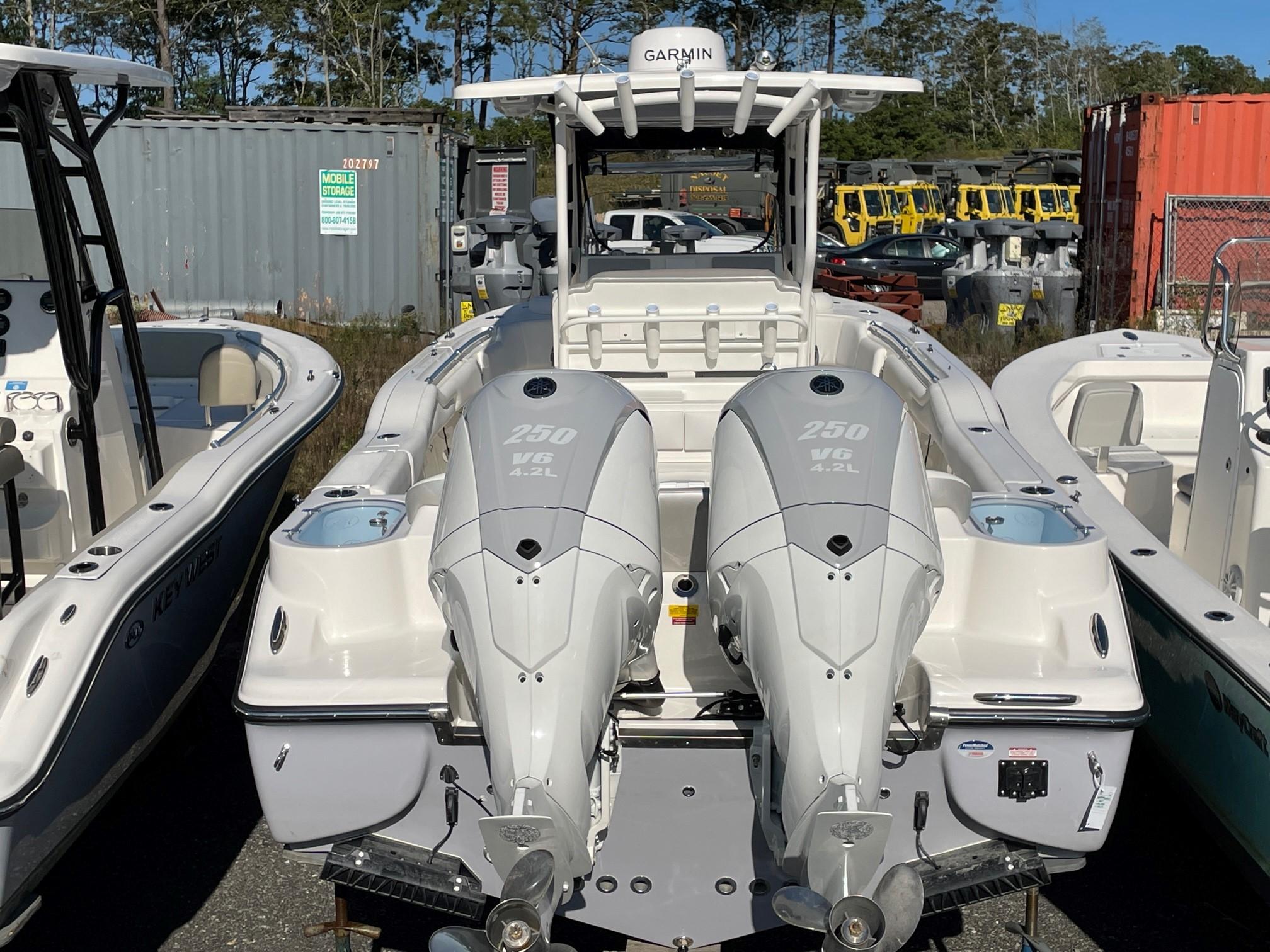 Slide: The Image of 2024 Key West 263 FS boat with twin 250 V6 engines in a storage yard. - 6