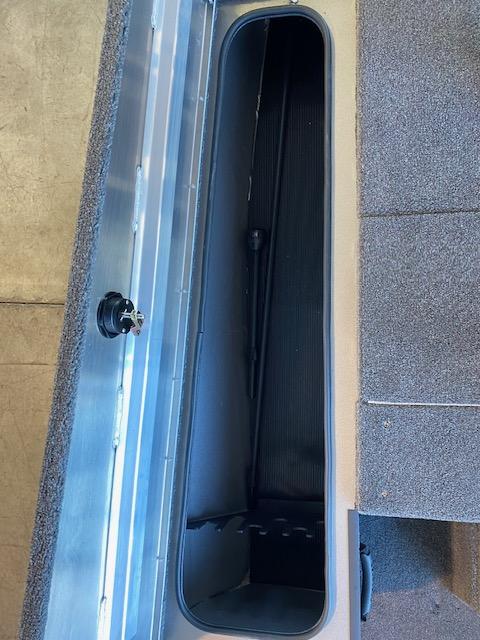 Slide: The Image of 2024 Lowe Stinger 175 Crappie boat storage compartment with carpeted interior. - 10