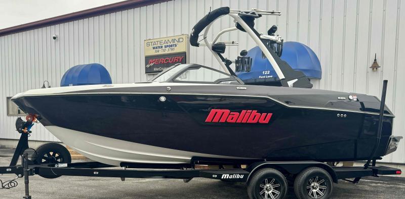Slide: The Image of 2024 Malibu M220 boat on trailer at dealership. - 1