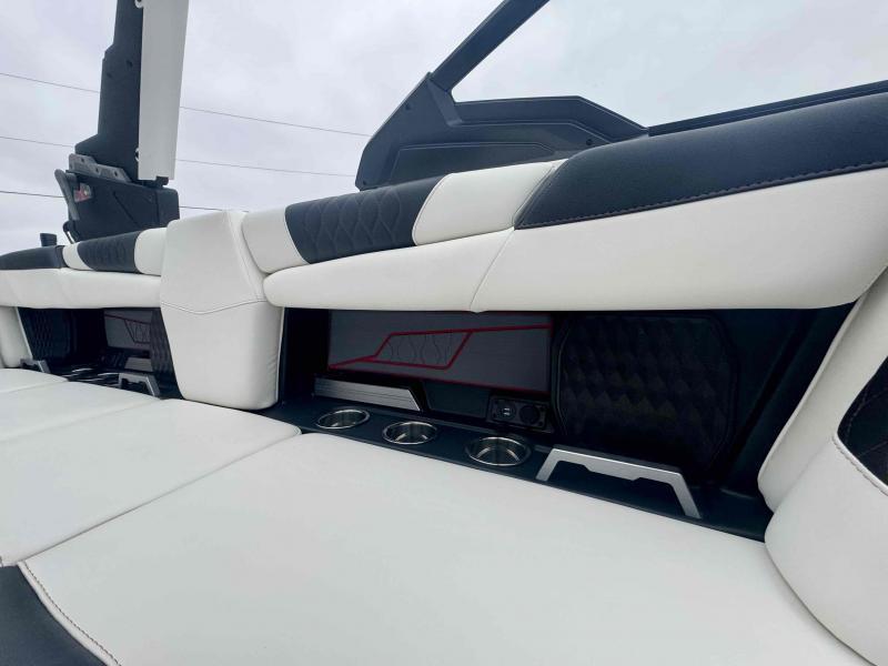 Slide: The Image of 2024 Malibu M220 boat interior with white and black seating, cup holders, and sleek design. - 19