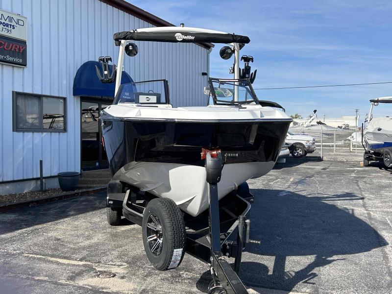Slide: The Image of 2024 Malibu M220 boat on a trailer outside a dealership. - 5