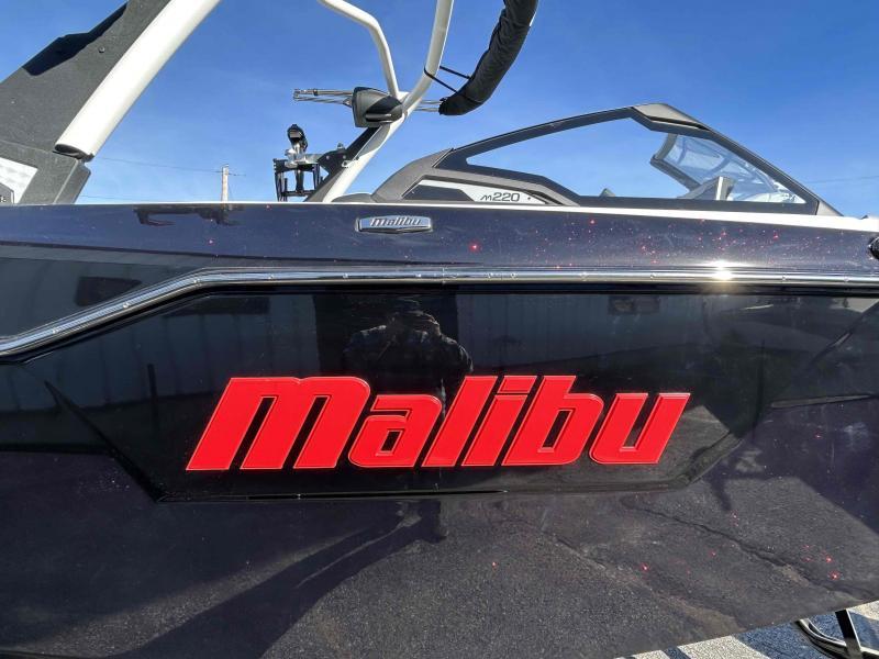 Slide: The Image of 2024 Malibu M220 boat with red logo and sleek design. - 8