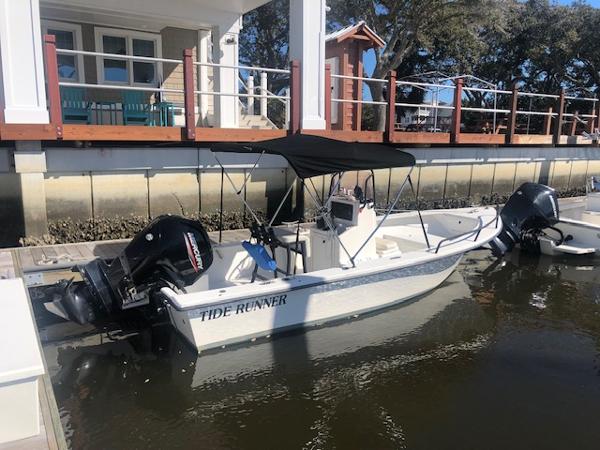 Slide: The Image of 2021 May-Craft 1800 Skiff boat named Tide Runner docked by a waterfront house. - 1