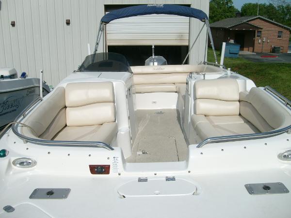 Slide: The Image of 2005 NauticStar 210 Sport Deck boat with beige seating and blue canopy. - 4