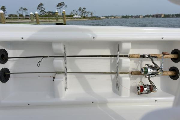 Slide: The Image of Fishing rod holders on a 2023 NauticStar 215 XTS boat, docked by the water. - 22