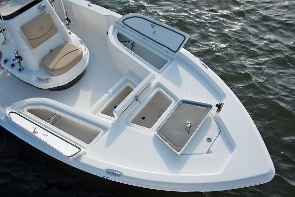 Slide: The Image of 2023 NauticStar 215 XTS boat with open storage compartments on the water. - 7