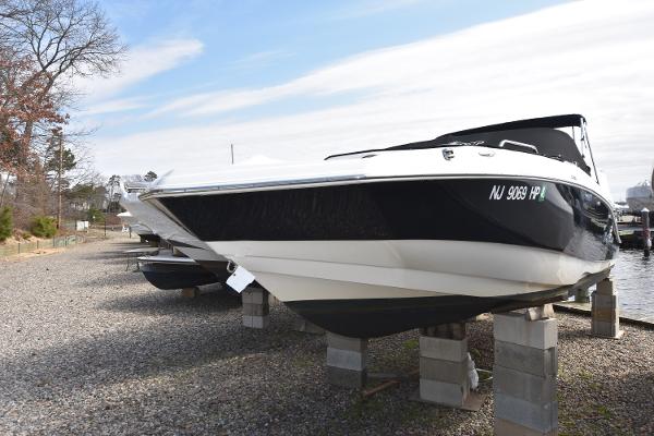 Slide: The Image of 2021 NauticStar 223 DC boat on blocks by the shore. - 0