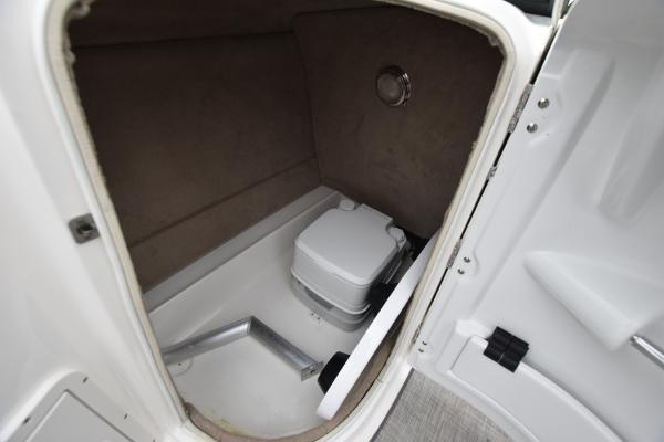 Slide: The Image of 2021 NauticStar 223 DC boat interior storage compartment with portable toilet. - 10