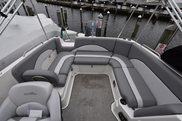 Slide: The Image of 2021 NauticStar 223 DC boat with spacious seating and modern design at a marina. - 12