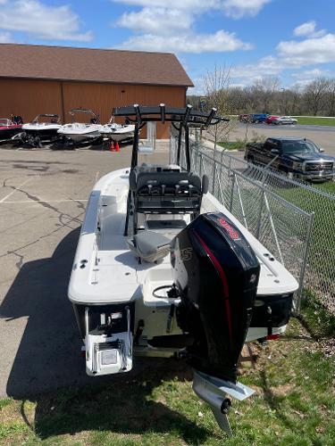 Slide: The Image of 2023 NauticStar 227 Bay boat with outboard motor in parking lot. - 2