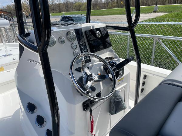 Slide: The Image of 2023 NauticStar 227 Bay boat console with steering wheel and navigation controls. - 5