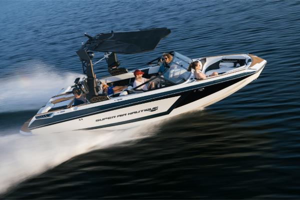 Slide: The Image of 2023 Nautique Super Air GS22E boat cruising on water with passengers. - 0