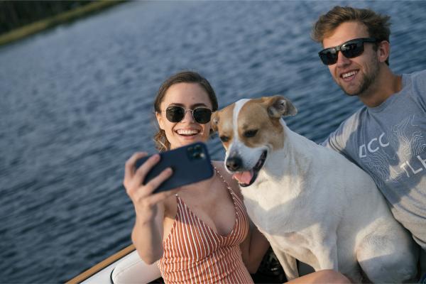 Slide: The Image of Couple and dog taking a selfie on a 2023 Nautique Super Air GS22E boat. - 36