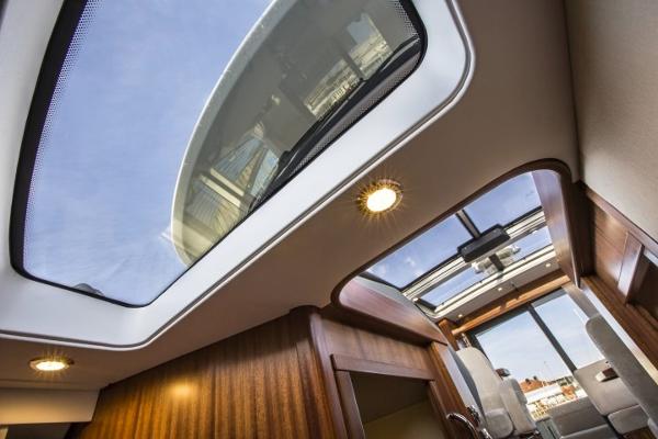 Slide: The Image of Interior view of 2025 Nimbus 405 Coupé with panoramic sunroof and wooden finishes. - 18