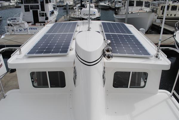 Slide: The Image of Nordic Tug 34 (2025) with solar panels docked at a marina. - 2