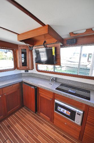Slide: The Image of 2025 Nordic Tug 34 kitchen with modern appliances and wood cabinetry - 6
