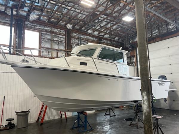 Slide: The Image of 2024 Parker 2520 XLD Sport Cabin boat in a warehouse. - 0