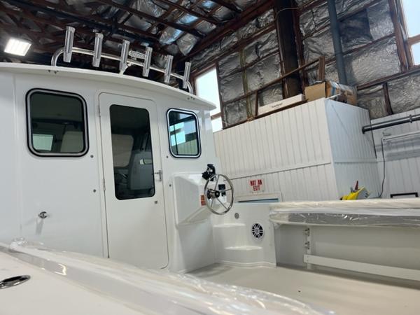 Slide: The Image of 2024 Parker 2520 XLD Sport Cabin boat interior in a warehouse. - 15