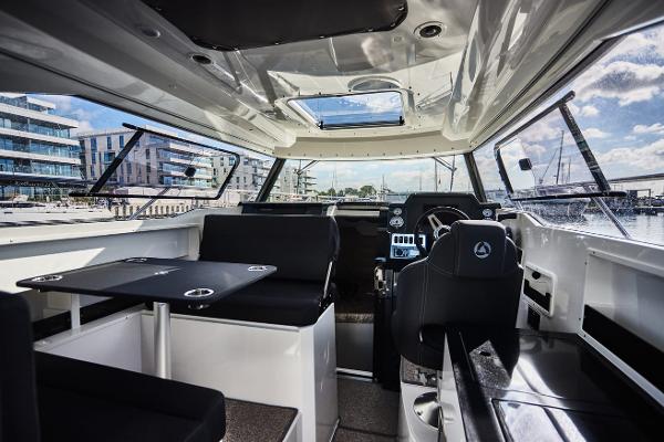 Slide: The Image of Interior of 2024 Parker Poland 920 Explorer Max boat with modern seating and navigation area. - 12