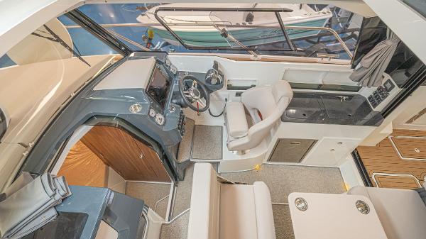 Slide: The Image of 2024 Parker Poland 920 Explorer Max interior with helm, seating, and kitchenette. - 7