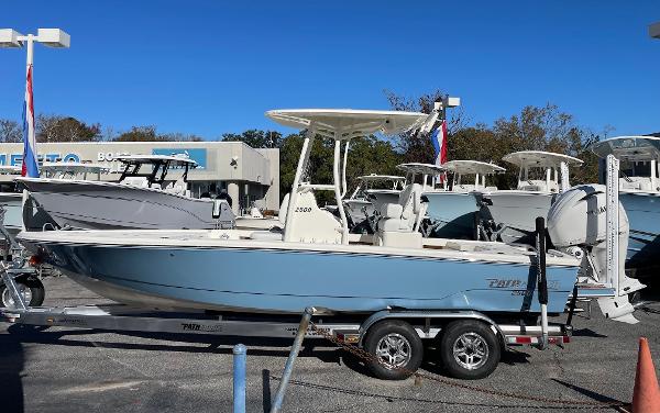 Slide: The Image of 2024 Pathfinder 2500 Hybrid boat on a trailer at a dealership. - 1