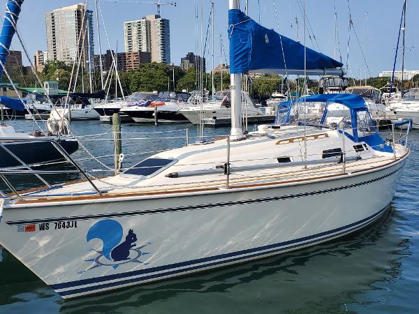 Slide: The Image of 1987 Pearson 31-2 sailboat docked in marina with city skyline background. - 0