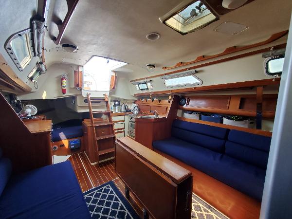 Slide: The Image of Interior of 1987 Pearson 31-2 sailboat with wooden furnishings and blue seating. - 17