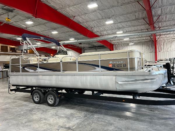 Slide: The Image of 2013 PlayCraft 2400 Clipper pontoon boat on trailer in indoor storage. - 1