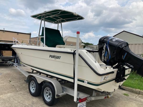Slide: The Image of 1998 Pursuit 2270 Center Console boat on a trailer with Mercury outboard motor. - 0