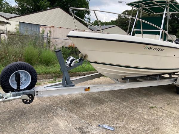 Slide: The Image of 1998 Pursuit 2270 Center Console boat on a trailer in a residential area. - 8